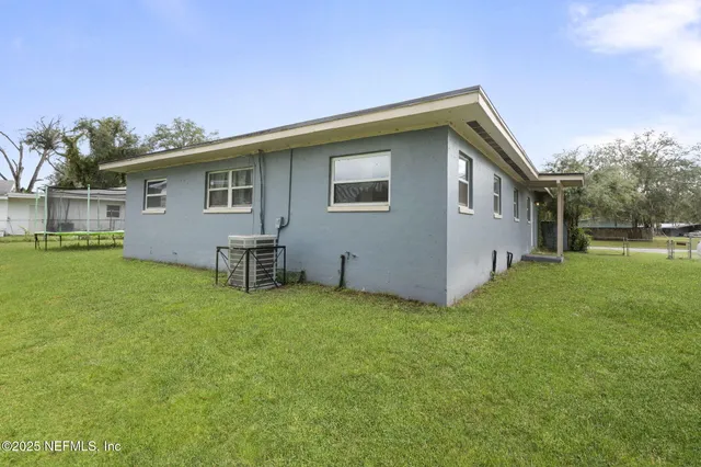 a view of house with garden and tall trees