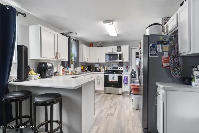 a kitchen with stainless steel appliances granite countertop a refrigerator sink and cabinets