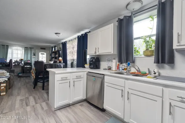 a kitchen with sink cabinets and wooden floor