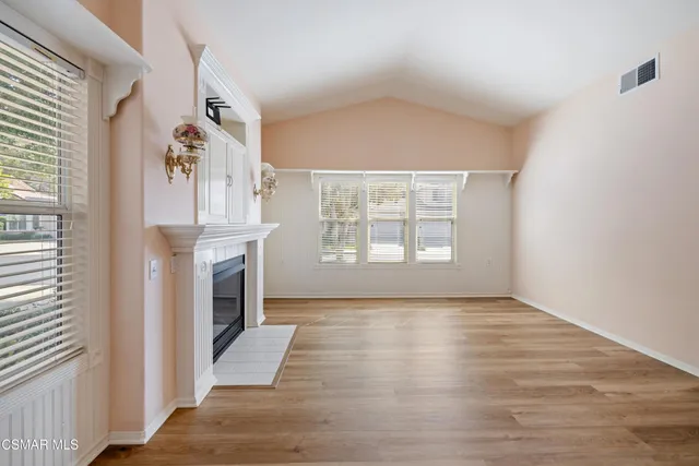 a view of an empty room with window and fireplace