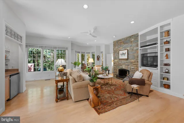 a living room with furniture a fireplace and a large window