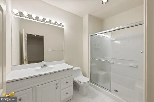 a bathroom with a shower sink vanity and mirror