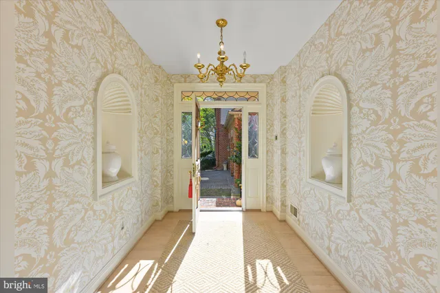 a view of a hallway with wooden floor and chandelier