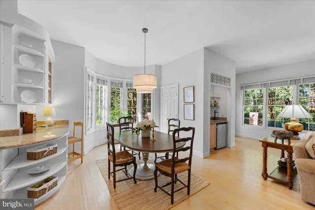 a view of a dining room and livingroom with furniture wooden floor a chandelier