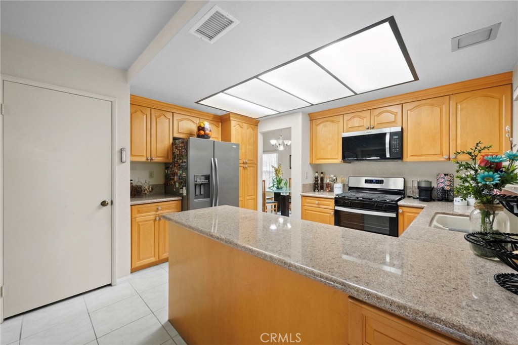 605 Bronco Way Walnut, CA 91789 - Photo 18 of 69 a large kitchen with granite countertop a large window and stainless steel appliances