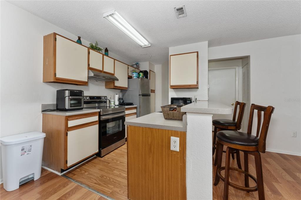 627 Dory Lane, Unit 304 Altamonte Springs, FL 32714 - Photo 17 of 28 a kitchen with stainless steel appliances granite countertop a stove a sink dishwasher and a refrigerator with wooden floor