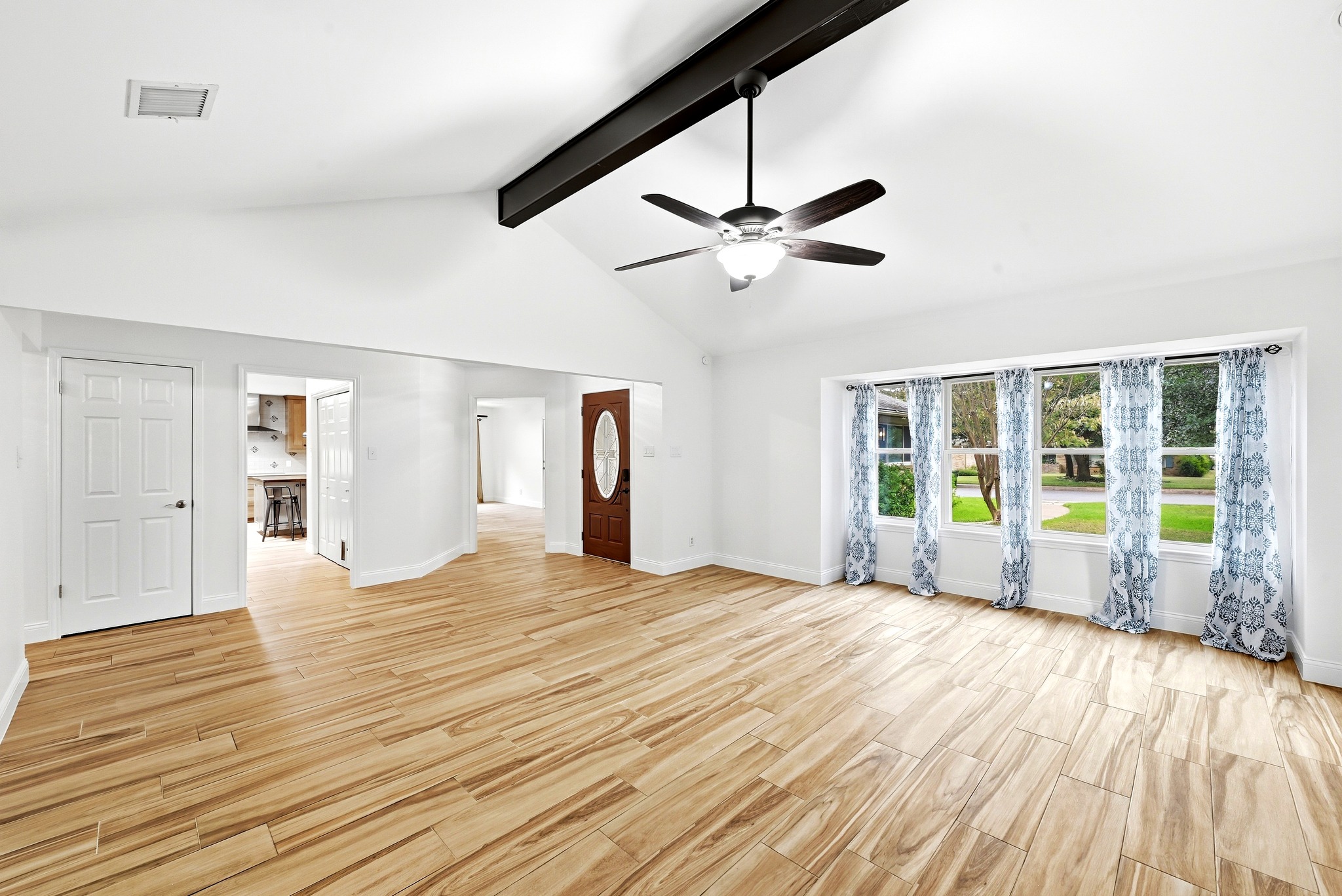 11218 Stormy Ridge Road Austin, TX 78739 - Photo 8 of 38 Gleaming wood-look tile floors complement the vaulted ceiling and natural light in this open area.