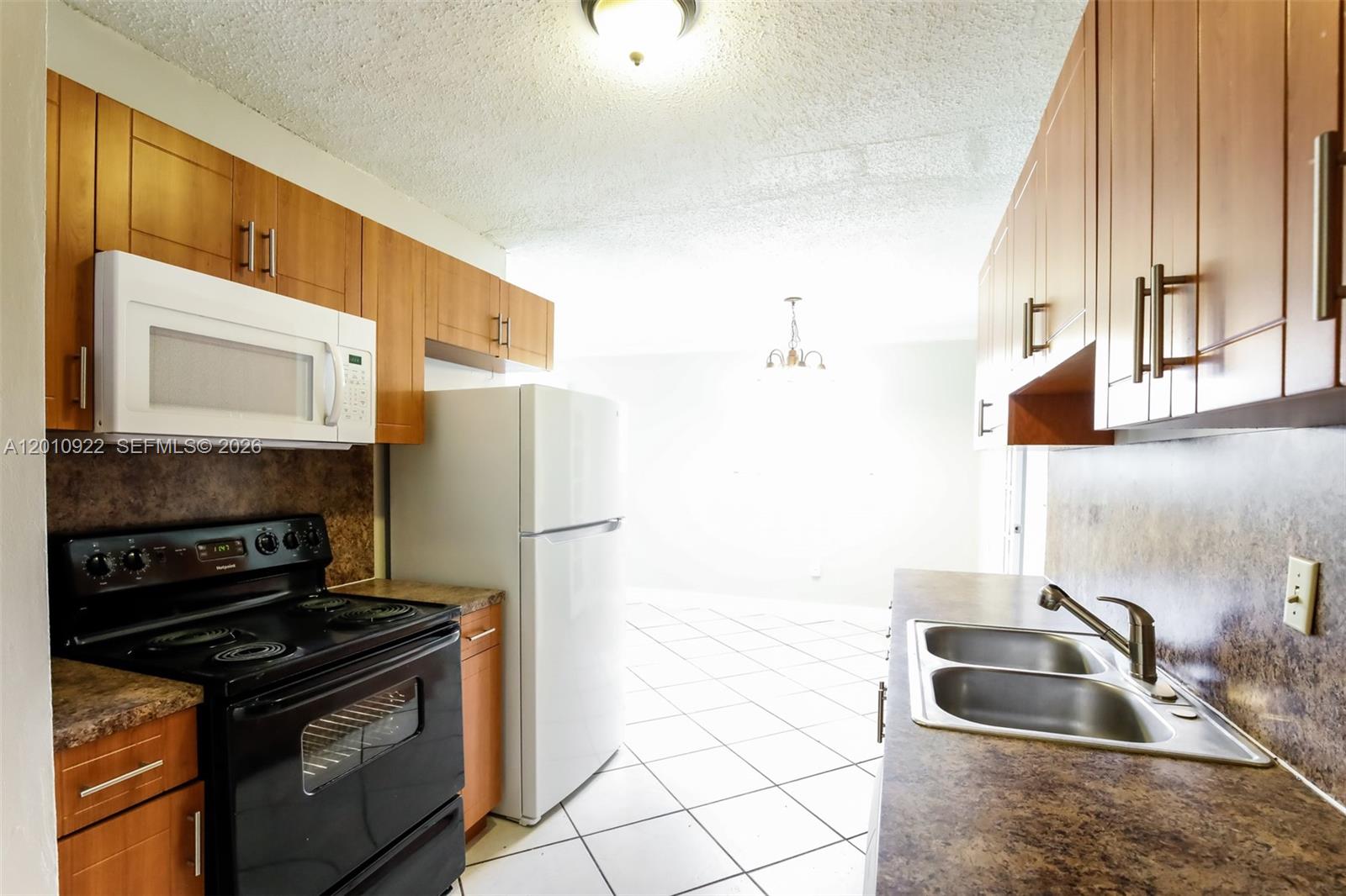 11460 Southwest 199th Street Miami, FL 33157 - Photo 7 of 18 a kitchen with granite countertop a sink stove and refrigerator