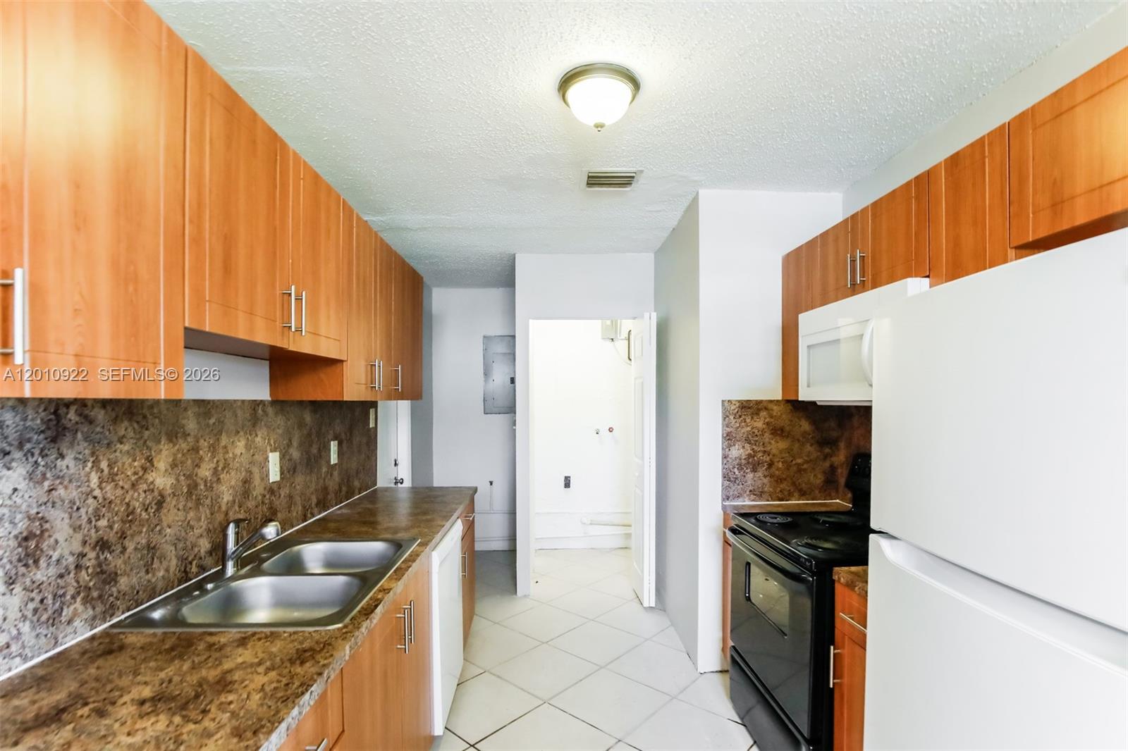 11460 Southwest 199th Street Miami, FL 33157 - Photo 8 of 18 a kitchen with granite countertop a sink a stove and a refrigerator