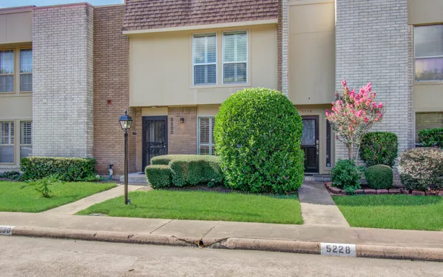 a front view of a house with a garden and plants