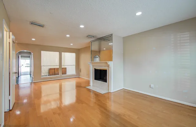 an empty room with wooden floor and fireplace