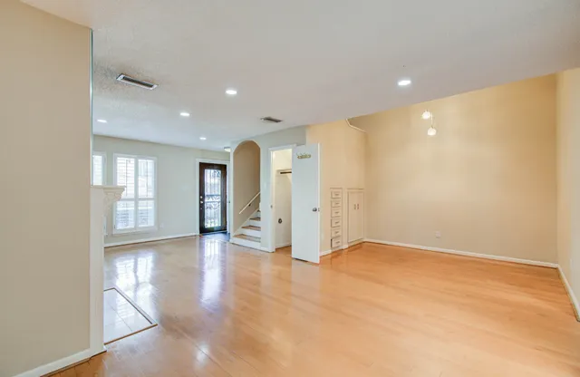 a view of empty room with wooden floor and windows