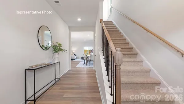 a view of a hallway with wooden floor and entryway