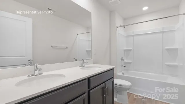 a bathroom with a sink double vanity granite toilet tub and shower