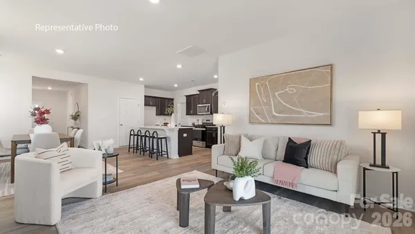 a living room with furniture and kitchen view