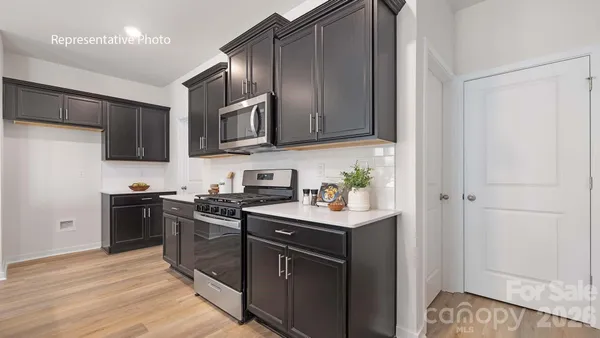 a kitchen with stainless steel appliances granite countertop a stove a sink and a refrigerator