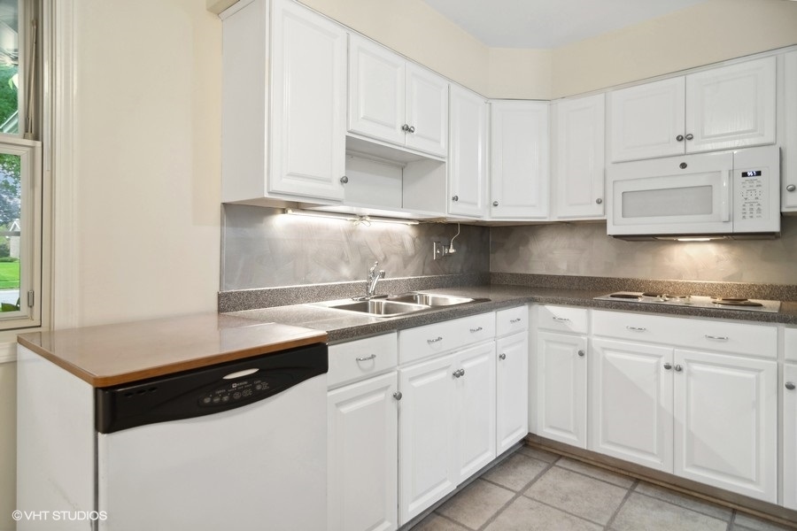 517 North Rohlwing Road Palatine, IL 60074 - Photo 8 of 17 a kitchen with granite countertop white cabinets and white appliances