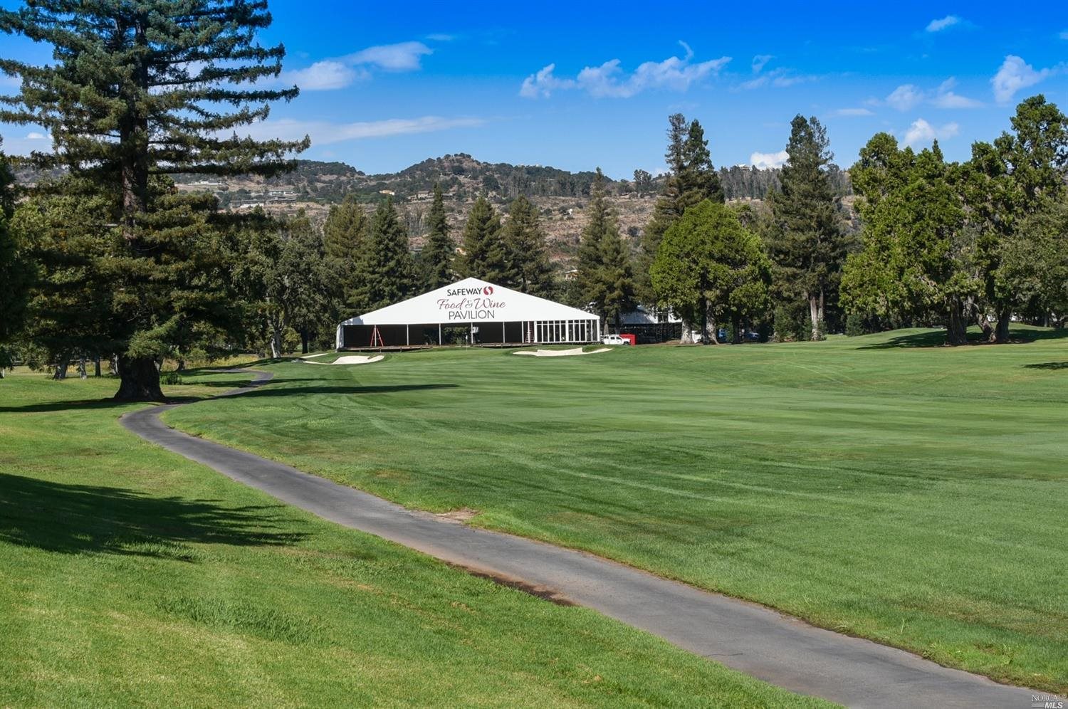 a view of a green field with an house in the background