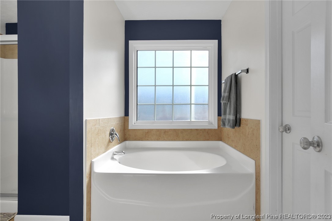 84 Loyalist Road Cameron, NC 28326 - Photo 30 of 40 a white bath tub sitting in a bathroom next to a window