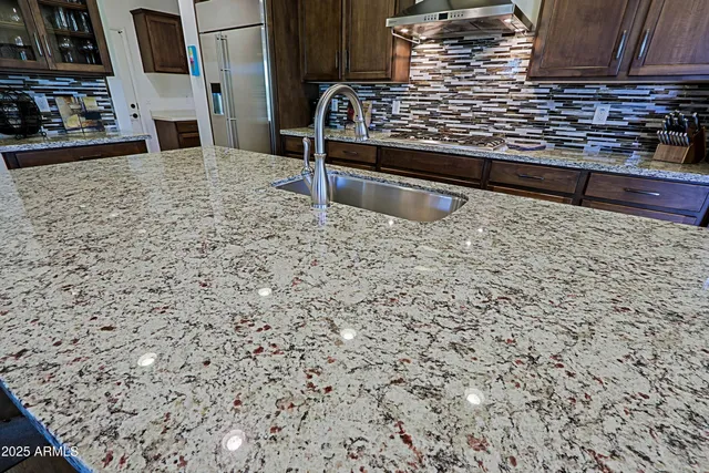 a kitchen with stainless steel appliances granite countertop a stove microwave and refrigerator