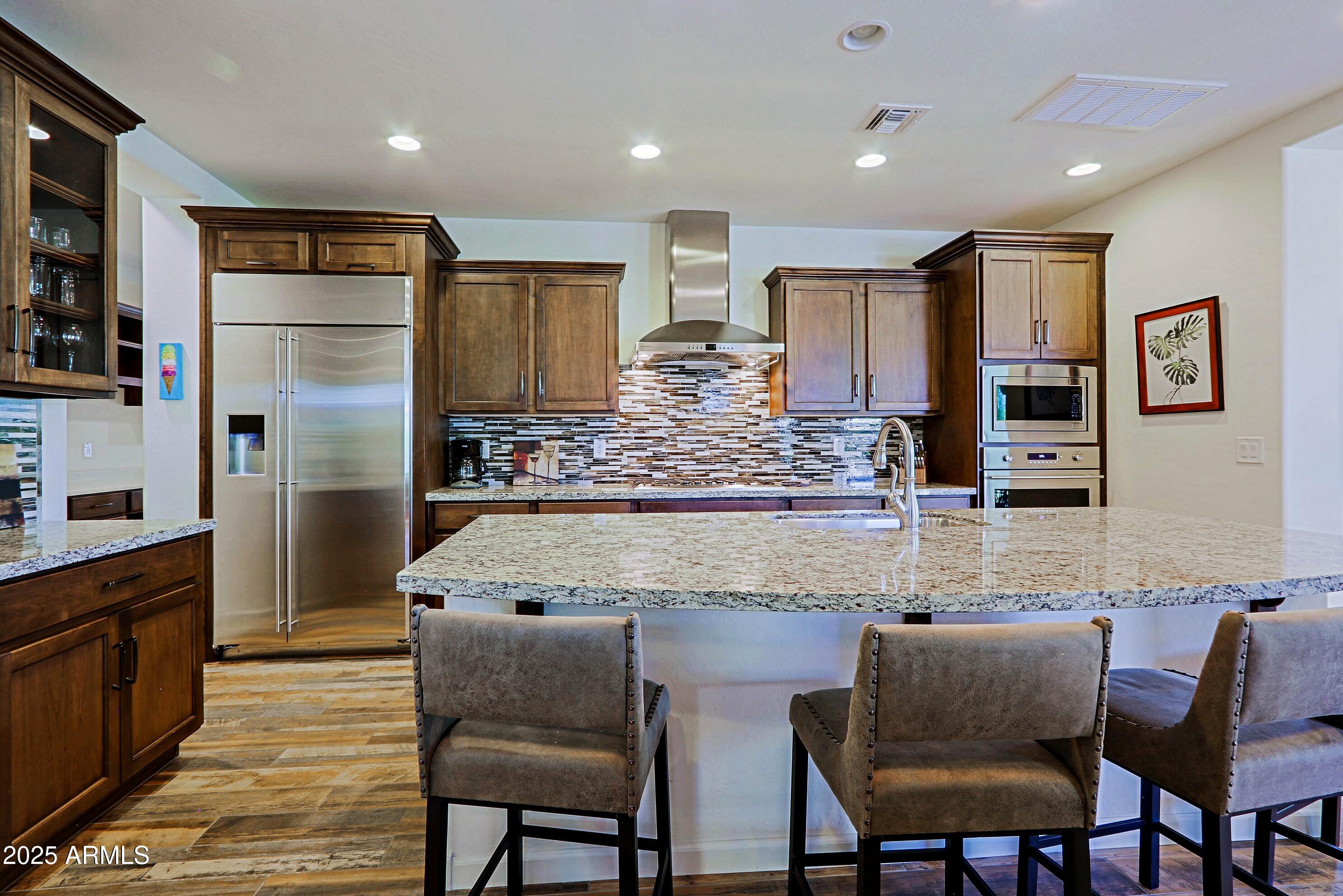 18004 East Silver Sage Lane Rio Verde, AZ 85263 - Photo 11 of 92 a kitchen with stainless steel appliances granite countertop a kitchen island a table and chairs
