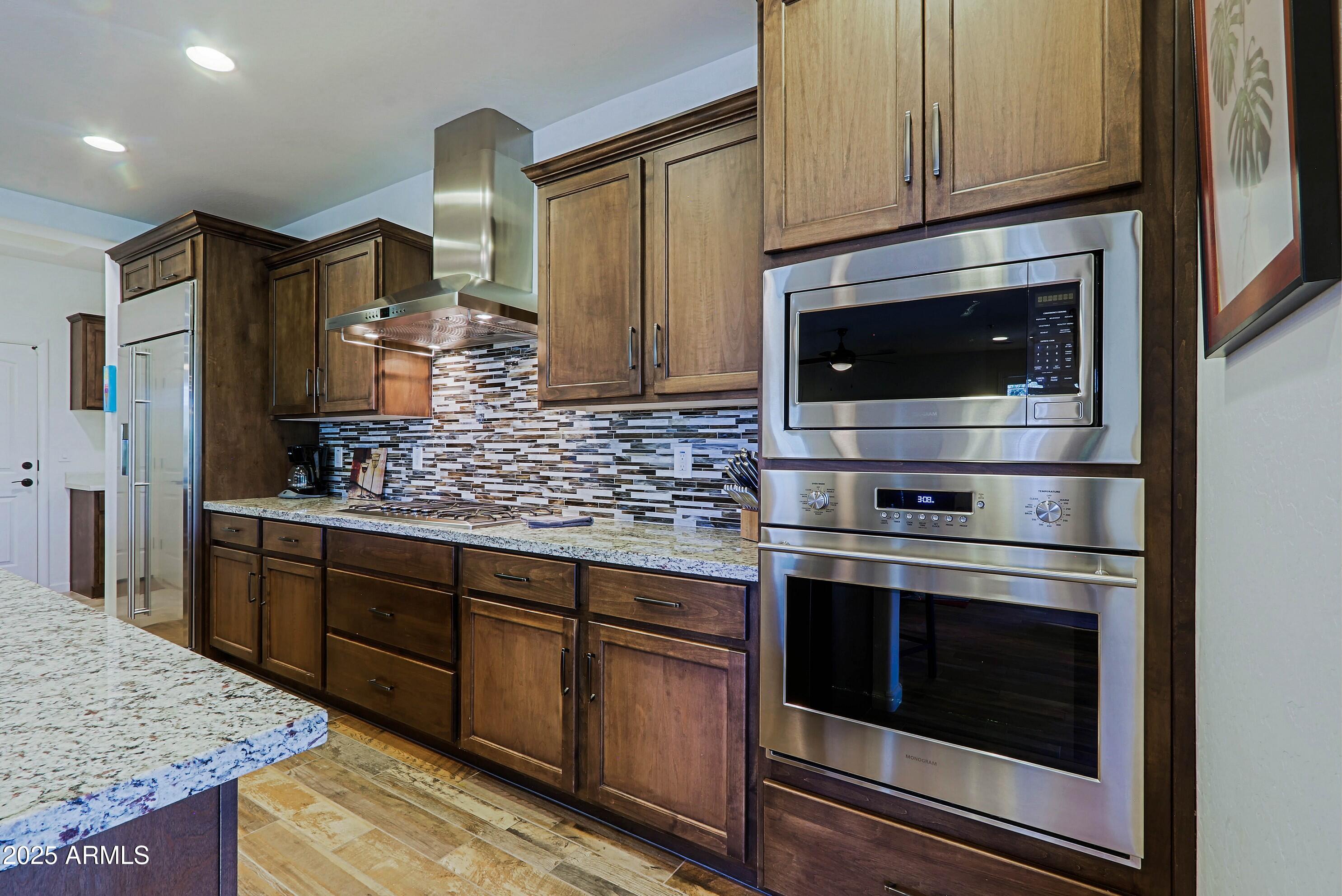 18004 East Silver Sage Lane Rio Verde, AZ 85263 - Photo 15 of 92 a kitchen with stainless steel appliances granite countertop a stove microwave and refrigerator