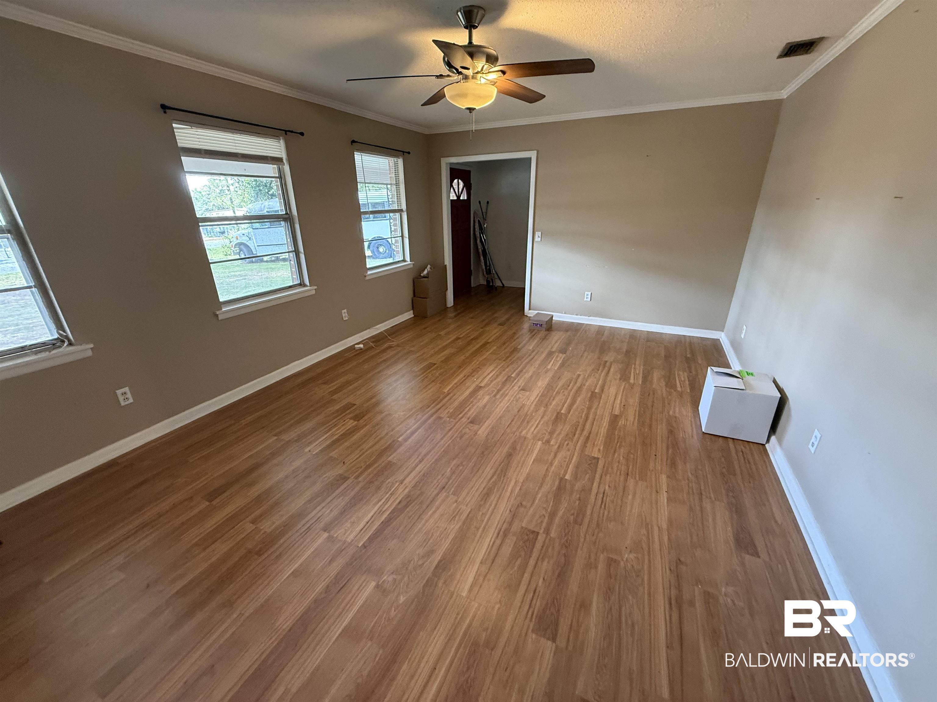 2807 Pea Ridge Road Brewton, AL 36426 - Photo 3 of 12 Spacious room featuring wood-finish flooring, neutral-toned walls, and white crown molding