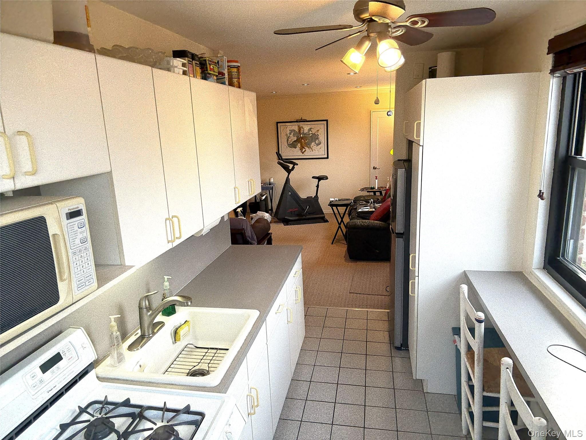 245-48 62nd Avenue, Unit UPPER 2/3BR Queens, NY 11362 - Photo 7 of 29 a living room with furniture and a chandelier