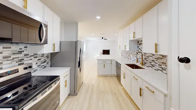 a kitchen with stainless steel appliances a stove a sink and a refrigerator