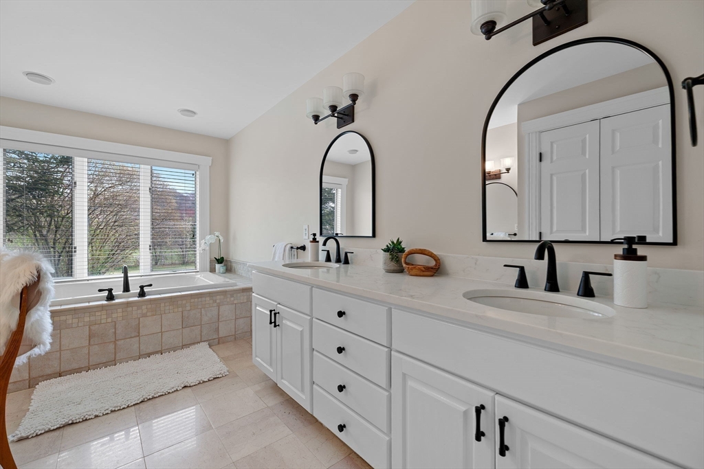 52 Pineswamp Road Ipswich, MA 01938 - Photo 16 of 41 a bathroom with double vanity sink a two mirror a window and a bathtub