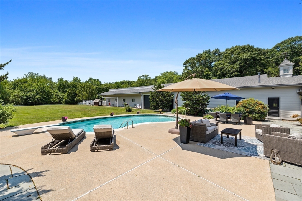 52 Pineswamp Road Ipswich, MA 01938 - Photo 10 of 41 a view of a swimming pool with lawn chairs under an umbrella