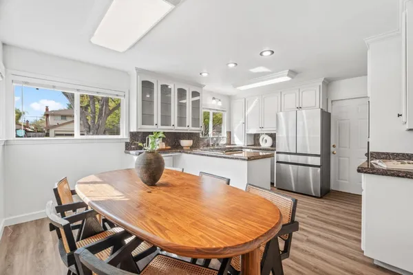 a kitchen with stainless steel appliances granite countertop a kitchen island a stove a table and chairs