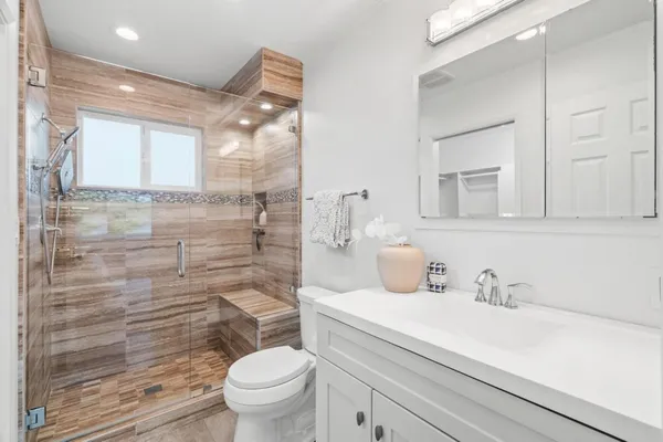 a bathroom with a sink a toilet and shower