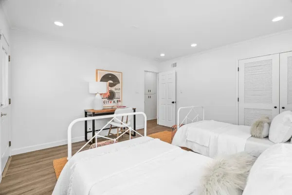 a bedroom with two beds and a desk