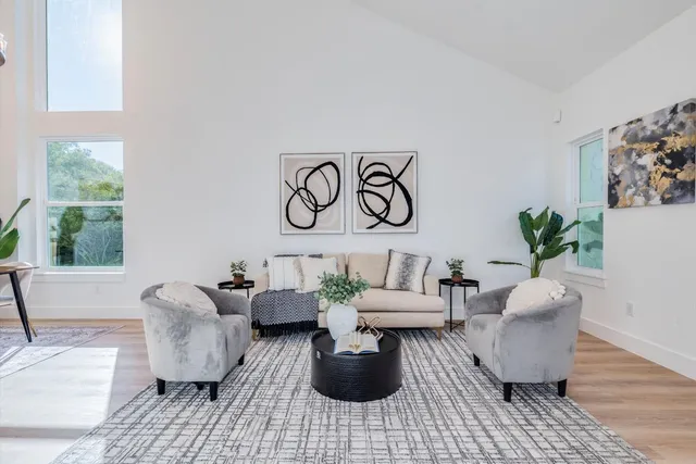 a living room with furniture and paintings on the wall