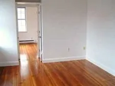 an empty room with wooden floor and a window