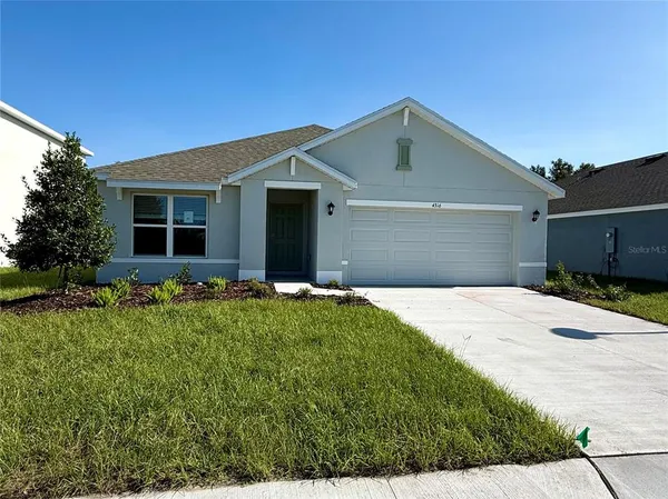 a front view of house with yard and trees around