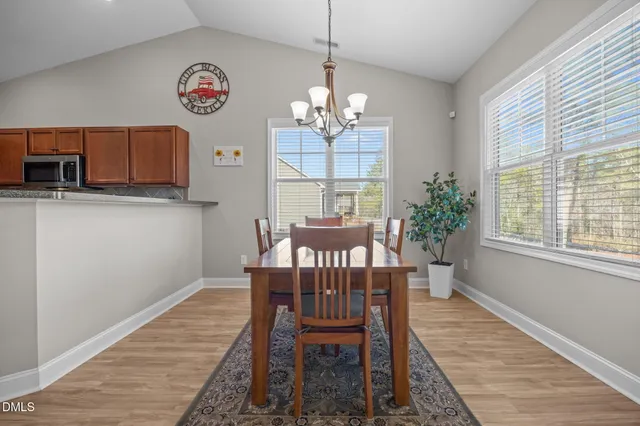 a view of a dining room with furniture a chandelier and wooden floor