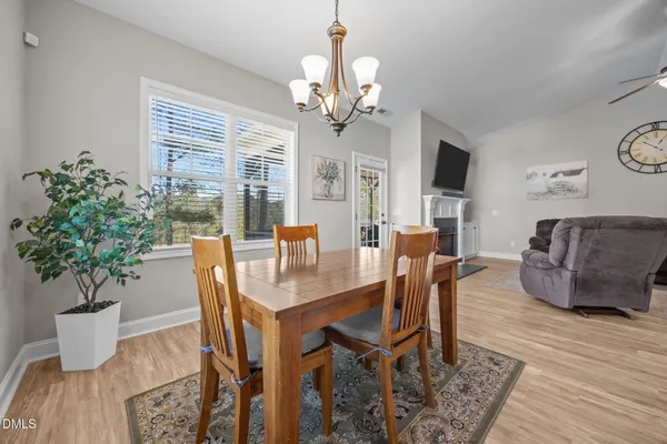 a view of a dining room with furniture a chandelier and wooden floor