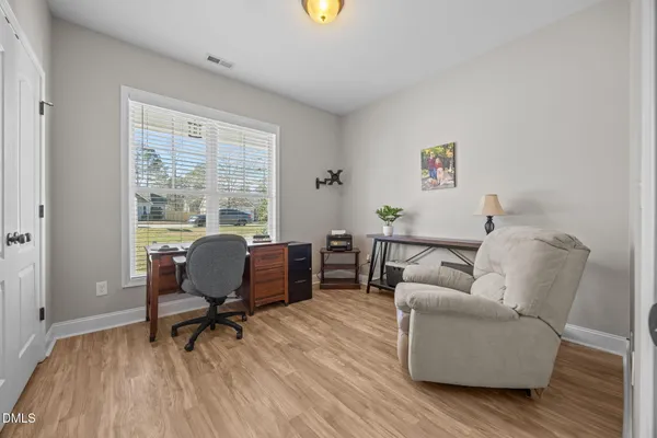 a bedroom with a bed and a lamp on dresser
