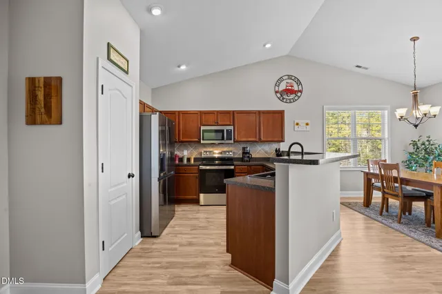 a kitchen with stainless steel appliances granite countertop a refrigerator and a stove top oven