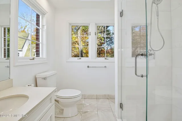 a bathroom with a granite countertop sink toilet and shower