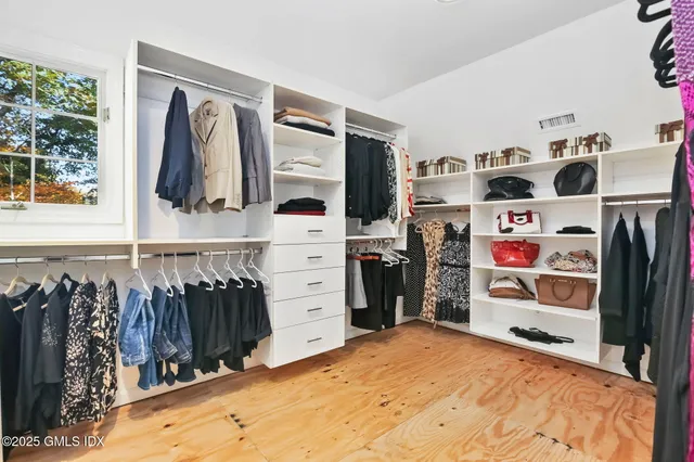 a view of walk in closet with clothes and shoes