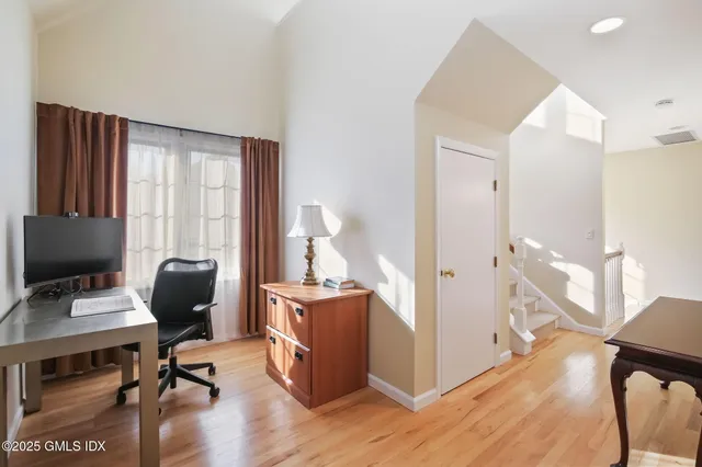 a view of a workspace with furniture and a window