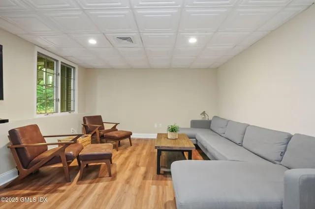 a living room with furniture wooden floor and a window