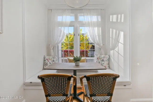 a view of a dining room with furniture and a large window