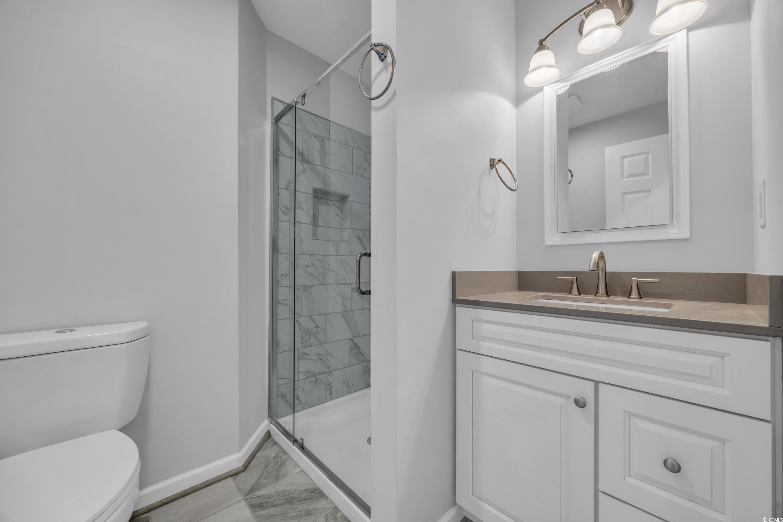 607 Jefferson Way Conway, SC 29526 - Photo 14 of 28 Bathroom featuring toilet, vanity, and a shower wi