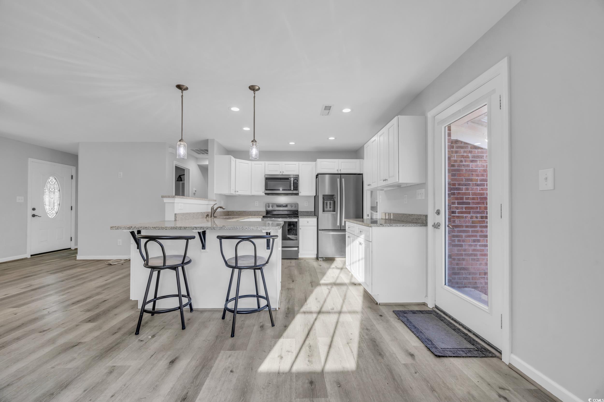 607 Jefferson Way Conway, SC 29526 - Photo 9 of 28 Kitchen with white cabinets, decorative light fixt