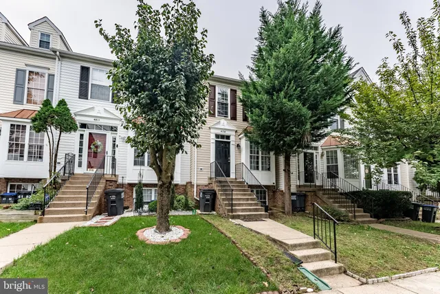 a front view of a house with a yard and tree