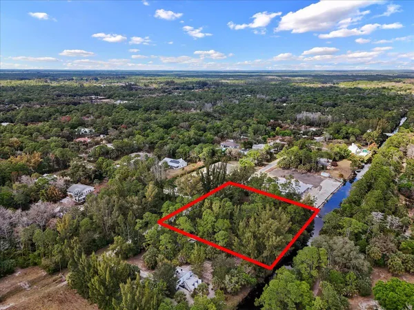 an aerial view of residential houses with outdoor space and trees